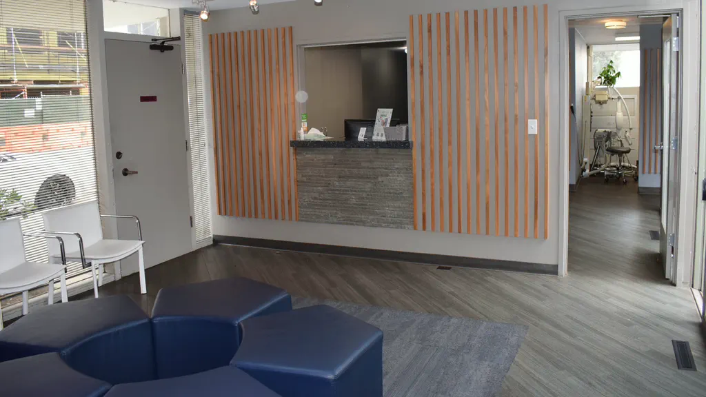 Reception and waiting area with wood-slat walls and navy seating