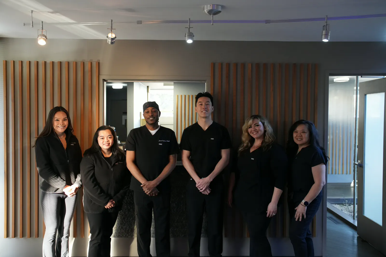 Dr. Christopher B. Wong and the dental team smiling together in the office reception area