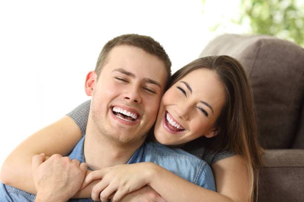 Happy couple with beautiful smiles after veneer treatment